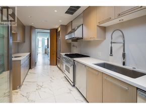 Vancouver apartment for rent - A modern kitchen with a marble floor and white countertops.
