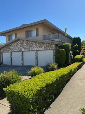 Oakland apartment for rent - A house with a stone wall and a garage door.