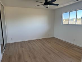 Oakland apartment for rent - A room with a ceiling fan and a window overlooking a parking lot.