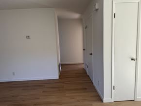 Oakland apartment for rent - A long hallway with white walls and wood floors.