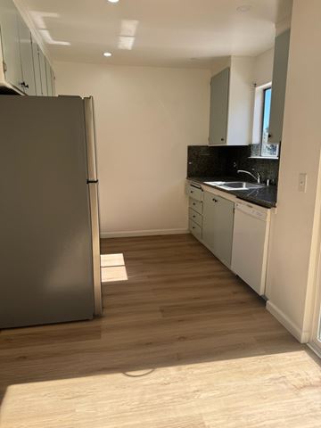 Oakland apartment for rent - A kitchen with a refrigerator, sink, and cabinets.