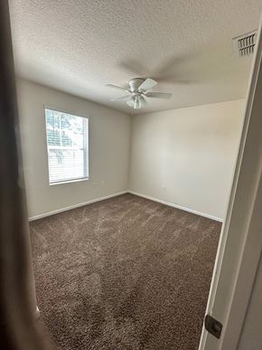 Green Cove Springs house for rent - A room with a ceiling fan and carpeted floor.