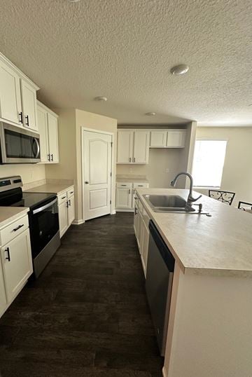 Green Cove Springs house for rent - A kitchen with white cabinets and a black counter top.
