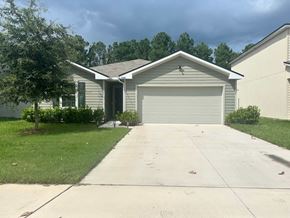 Green Cove Springs house for rent - A house with a grey garage door and a tree in front.
