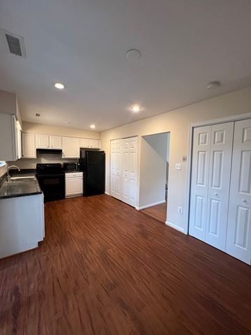 Capitol Heights house for rent - A kitchen with black appliances and white cabinets.