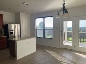 Cedar Park house for rent - A kitchen with a refrigerator, cabinets, and a countertop.