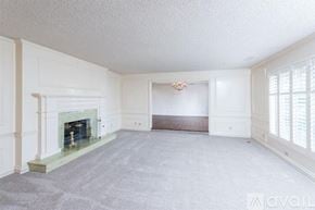 Fresno apartment for rent - A spacious living room with a fireplace and a chandelier.