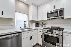 San Diego apartment for rent - A kitchen with white cabinets and a stainless steel oven.