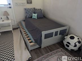San Diego apartment for rent - A bedroom with a bed, a soccer ball, and a lamp.
