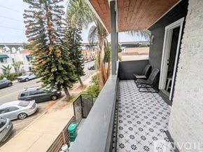San Diego apartment for rent - A balcony with a patterned floor and a view of a street with cars and trees.
