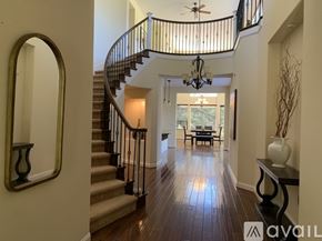 Nipomo house for rent - A spacious hallway with a staircase and a chandelier.