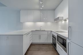 Edmonton apartment for rent - A modern kitchen with white cabinets and appliances.