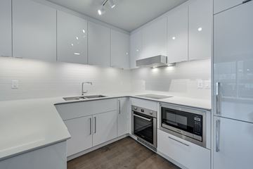 Edmonton apartment for rent - A modern kitchen with white cabinets and appliances.