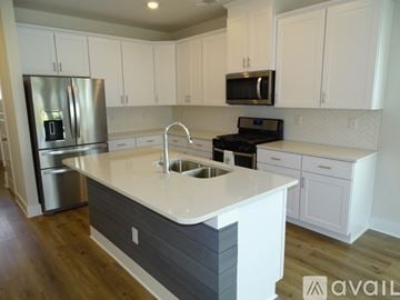 Greenville house for rent - A kitchen with white cabinets and a grey island.