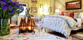 Lake Lure house for rent - A bedroom with a bed covered in a blue and white patterned blanket.