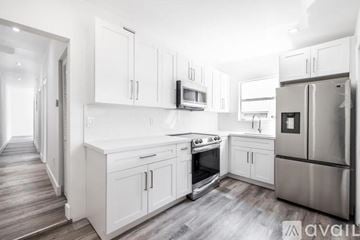 Miami house for rent - A kitchen with white cabinets and stainless steel appliances.