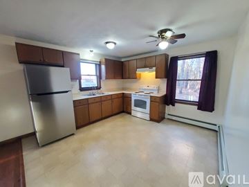 North Berwick apartment for rent - A kitchen with a refrigerator, oven, and a window with a view of trees.
