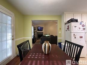 Riverdale house for rent - A dining room with a brown table and a vase on it.