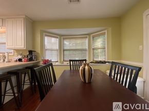 Riverdale house for rent - A kitchen with a table and chairs in front of a window.