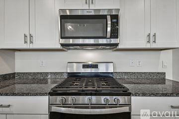 Davenport house for rent - A kitchen with brown cabinets and a marble countertop.