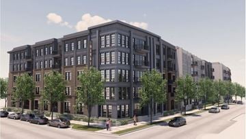 Birmingham apartment for rent - A street view of a modern apartment building with cars parked on the side of the road.