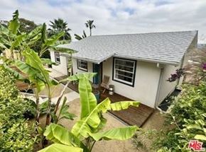 Los Angeles apartment for rent - A small white house with a grey roof surrounded by green plants.