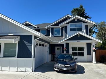 Victoria apartment for rent - A two-story house with a garage and a car parked in front.