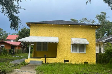 Jacksonville house for rent - A yellow house with a red roof in the background.