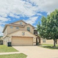Killeen house for rent - A house with a brown garage door is in front of a tree.