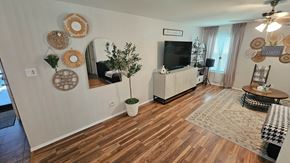 Killeen house for rent - A living room with a wooden floor and a flat screen TV mounted on the wall.