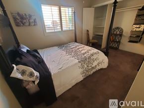 Chino house for rent - A bedroom with a bed, a chair, and a window with blinds.