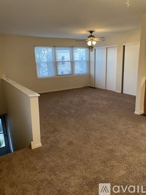 Philadelphia apartment for rent - A room with a carpeted floor, a ceiling fan, and a window with a view of a building outside.