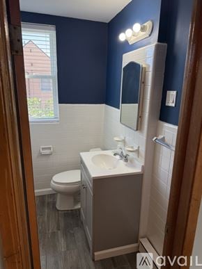 Philadelphia apartment for rent - A room with a ceiling fan, a window with blinds, a radiator on the wall, and a wooden door.