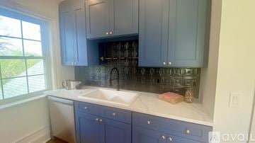Lenoir apartment for rent - A kitchen with blue cabinets and a white countertop.