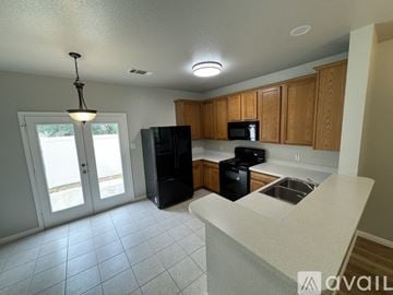 Austin house for rent - A kitchen with black appliances and wooden cabinets.