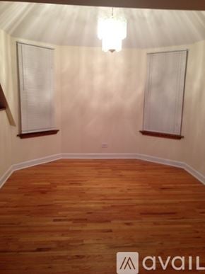 Chicago apartment for rent - A room with wooden floors and two windows.