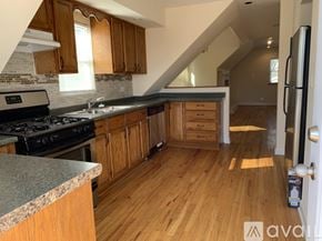 Chicago apartment for rent - A kitchen with wooden cabinets and a black stove top oven.