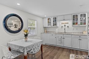 Ocean Isle Beach house for rent - A kitchen with a table and chairs in the foreground and a large mirror on the wall.