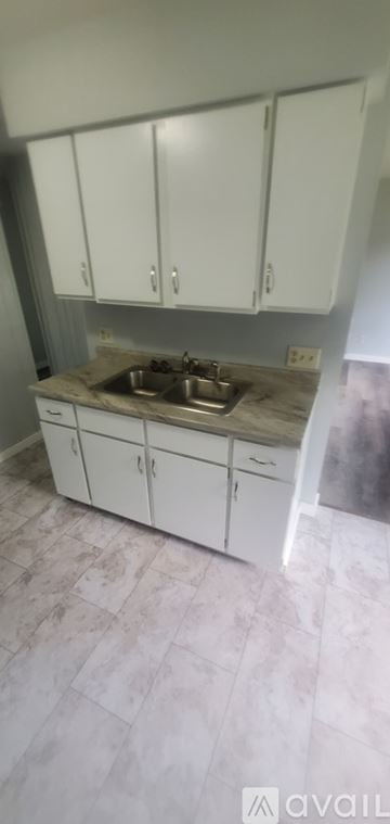 La Crosse apartment for rent - A kitchen with white cabinets and a marble countertop.