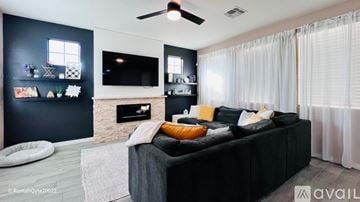 Phoenix house for rent - A modern living room with a black couch and a fireplace.