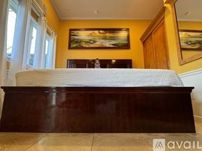 Honolulu apartment for rent - A bedroom with a bed, a wooden cabinet, and a window.