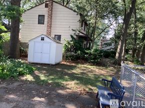 Pennsauken apartment for rent - A backyard with a shed, a bench, and a fence.
