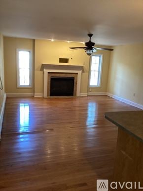 Pennsauken apartment for rent - A living room with a fireplace and a ceiling fan.