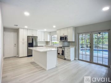 Naples house for rent - A modern kitchen with white cabinets and a large island.