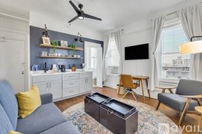 Savannah apartment for rent - A living room with a grey sofa, a coffee table, and a flat screen TV mounted on the wall.