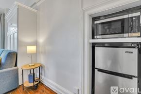 Savannah apartment for rent - A kitchen area with a refrigerator, a table with a lamp, and a chair.