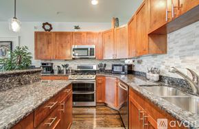 Houston apartment for rent - A kitchen with wooden cabinets and granite countertops.