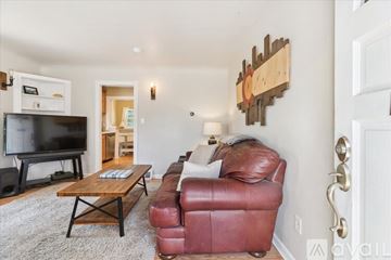 Englewood house for rent - A living room with a red leather couch and a wooden coffee table.