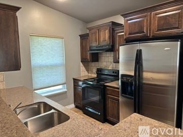 Edmond house for rent - A kitchen with a stainless steel refrigerator, oven, and sink.
