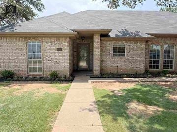 Wichita Falls house for rent - A house with a brown roof and a brick exterior has a white door and windows.